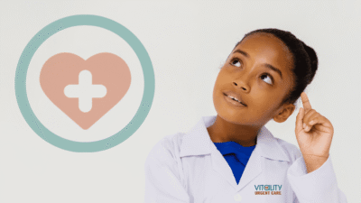 Child in lab coat looking at medical heart symbol representing pediatric urgent care services at Vitality Urgent Care